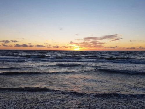 a sunset over the ocean with waves at 2 person holiday home in Brovst-By Traum in Brovst