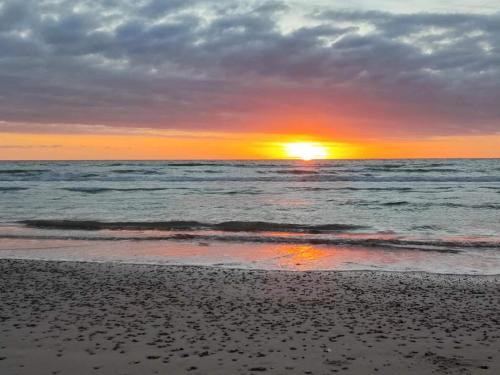 a sunset on the beach with the ocean at 2 person holiday home in Brovst-By Traum in Brovst