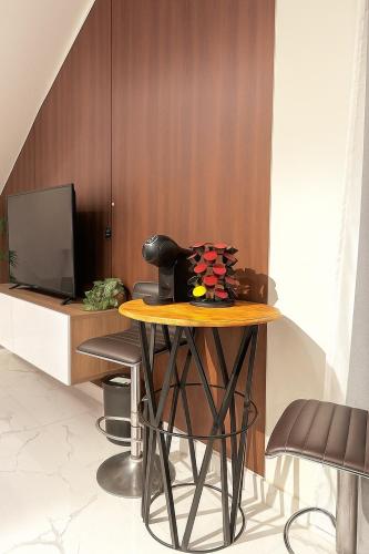 a table with chairs and a television in a room at Jasmine Corner Chalet in Mawāliḩ