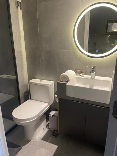 een badkamer met een toilet, een wastafel en een spiegel bij Studio no condomínio Almagah SPaulo in Sao Paulo