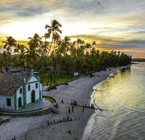 a group of people on a beach next to a building at Praia dos Carneiros- Varanda Carneiros Club Meridional in Tamandaré