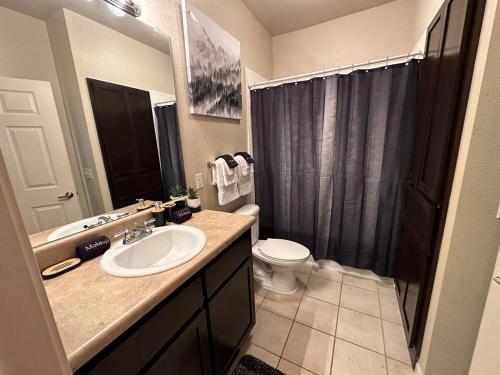 a bathroom with a sink and a toilet and a shower at Magnolia Oasis - 2BD-2BA - Gym, Pool, BBQ Grill in Tupelo