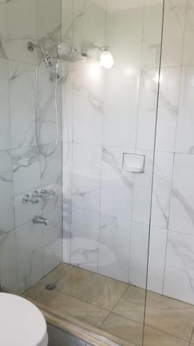 a bathroom with a glass shower with a toilet at Paradise Home in Discovery Bay
