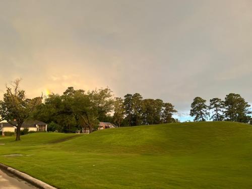 a green hill with a rainbow in the sky at Golfers' Paradise 3BR Single House with Private Pool & Golf Course View- Man Gated, Marina in Lake Conroe, Tennis courts & Gym Access in Montgomery