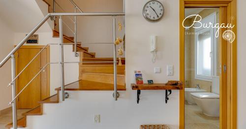 a bathroom with a staircase with a toilet and a clock at Burgau Charming House Villa in Burgau