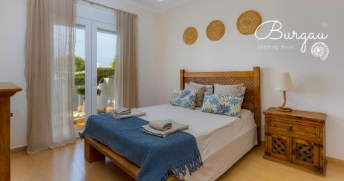 a bedroom with a bed with two towels on it at Burgau Charming House Villa in Burgau