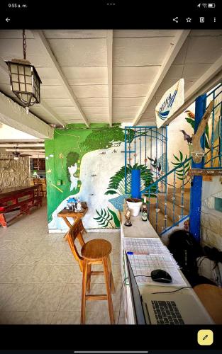 a room with a table and chairs and a mural at Taida Hostel Rincón del Mar in Rincón