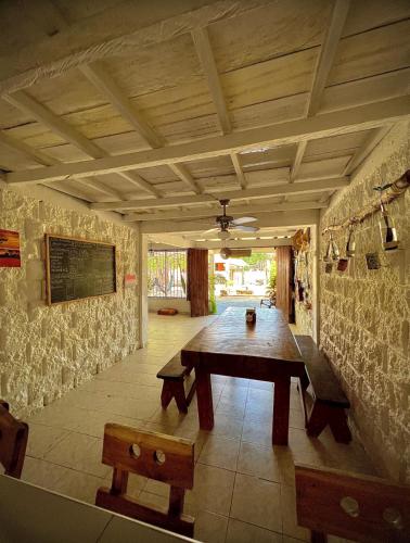 a dining room with a wooden table and benches at Taida Hostel Rincón del Mar in Rincón