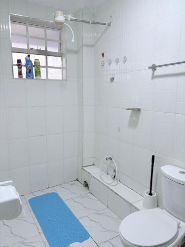 a bathroom with a toilet and a blue rug at Kevara by H&D Stays in Nanyuki