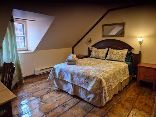 a bedroom with a large bed in a attic at Gîte À l'Augustine in Quebec City