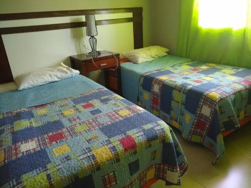 two beds in a room with a quilt on them at La Pichona relax in Tafí Viejo
