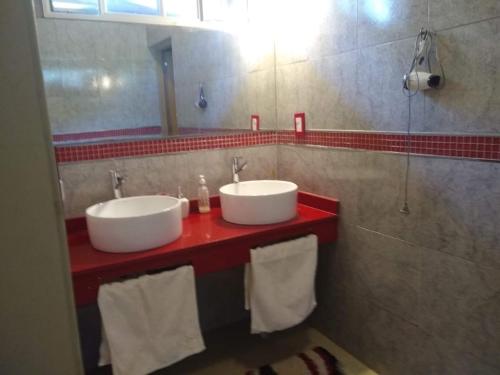 a bathroom with two sinks on a red counter at La Pichona relax in Tafí Viejo
