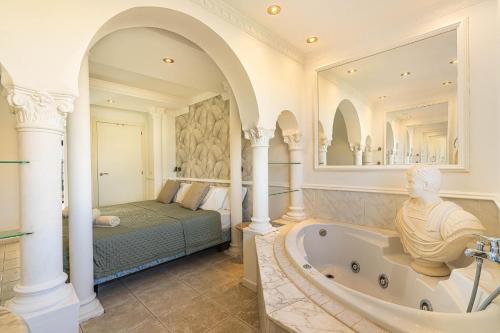 a master bathroom with a tub and a bed at As de Casas - Parque Albatros 2 in San Miguel de Abona