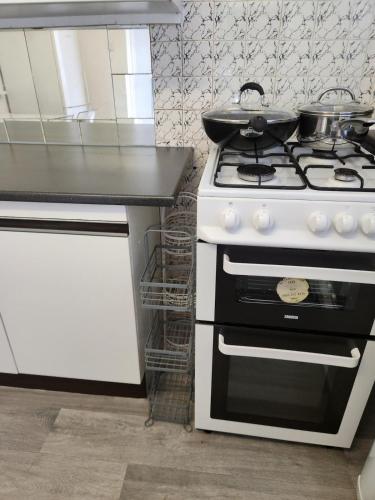 a kitchen with a stove with a pan on top of it at Beautiful two Bedroom house Entire house in Stevenage