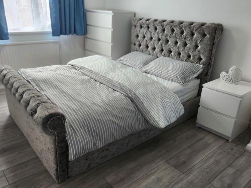 a bedroom with a bed with a tufted headboard at Beautiful two Bedroom house Entire house in Stevenage