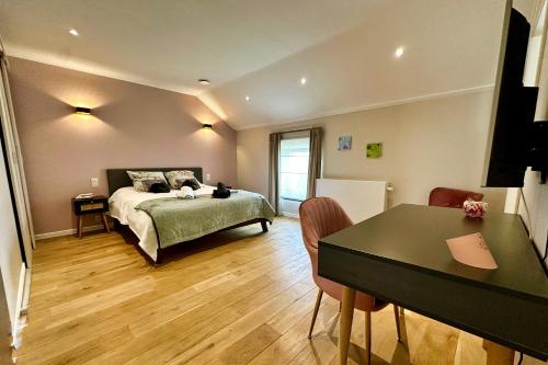 a bedroom with a bed and a table in it at B&B Le Relais de Lou 