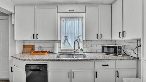 a kitchen with white cabinets and a sink and a microwave at Fall Break Specials! 4 Beds; Great for Lake Myrtle in Auburndale