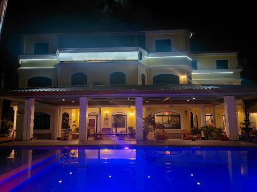 a large house with a swimming pool at night at Villa Italia Hotel in Sorsogon