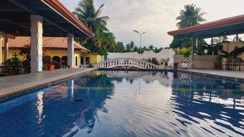 a swimming pool in a house with a bridge at Villa Italia Hotel in Sorsogon