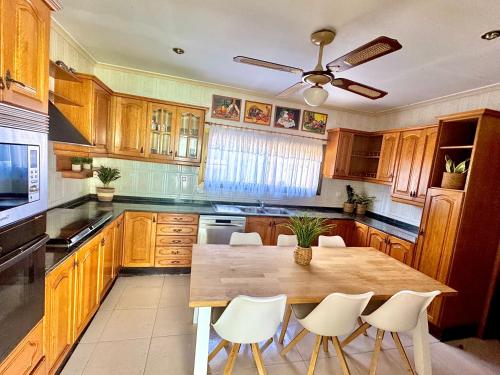 a kitchen with a wooden table and white chairs at Serena Villa in Benicarló