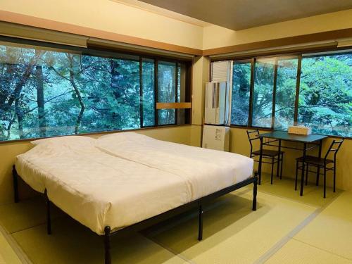 a bedroom with a bed and a table with chairs at Hakonesaryo Kintoki in Hakone