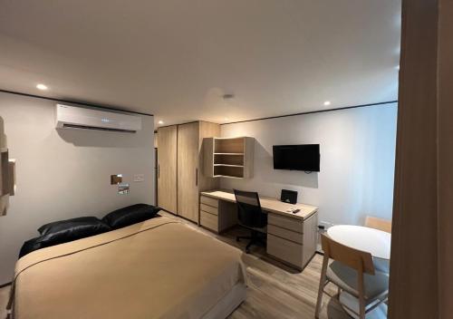 a bedroom with a bed and a desk and a computer at Cozy Maho Studio w Pool Gym & Nearby Beaches in Maho Reef