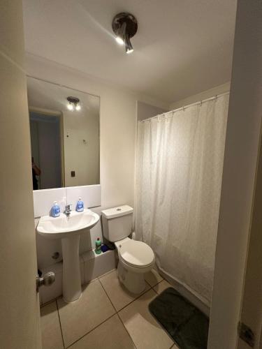 a bathroom with a toilet and a sink and a mirror at Dpto Playa Casino Marina Sol in Coquimbo