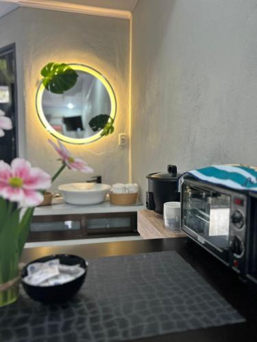 a kitchen with a microwave and a vase of flowers at Residencia Esmeralda in Agua Buena