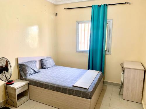 a bedroom with a bed with a blue curtain at Dakar Logement in Dakar