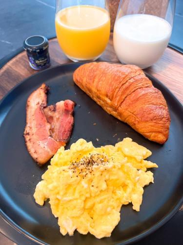 een bord met eten, eieren, ham, brood en sinaasappelsap bij Party House Heaven in North Hollywood