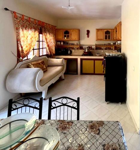 a living room with a couch and a kitchen at Spacious Villa with Fireplace for an Unforgettable Stay in El Jadida