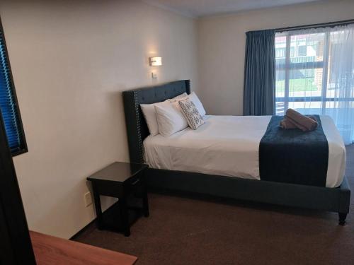 a hotel room with a bed and a window at Palm City Motor Inn in Napier