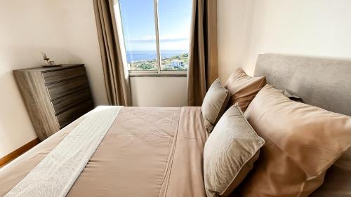 a bedroom with a bed with a large window at Mãe de Deus - Caniço - Madeira in Caniço