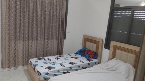 a bedroom with two twin beds and a window at شقة لي الكراء في حي المطار in Nador