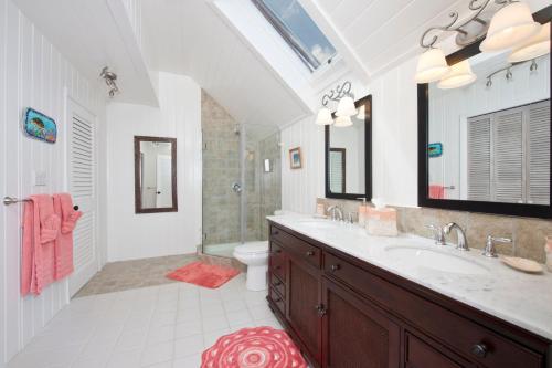 a bathroom with a sink and a shower and a toilet at Tourmaline home in Governorʼs Harbour