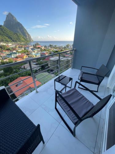 two chairs on a balcony with a view of the ocean at Caldera Villas in Soufrière