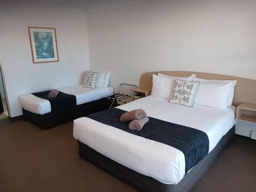 a hotel room with two beds with towels on them at Palm City Motor Inn in Napier