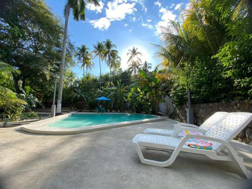 una piscina con due sedie a sdraio accanto di Rancho el Cocalito a La Libertad