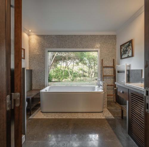 a large bath tub in a bathroom with a window at Sintra - Praia Grande Village in Colares