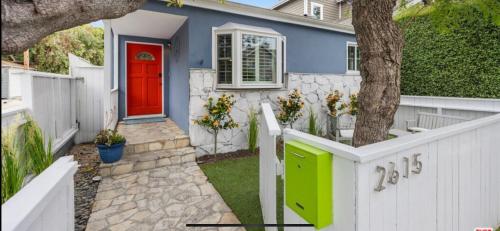 a house with a red door and a white fence at Chic Venice Beach Bungalow Steps from the Canals & Beach in Los Angeles