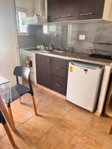 a kitchen with a sink and a white refrigerator at Departamentos Ines in Villa María