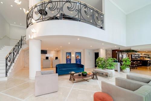 a living room with a blue couch and a staircase at Hotel Mercu Privi Moema Ibirapuera com ar e piscina 1810 in Sao Paulo