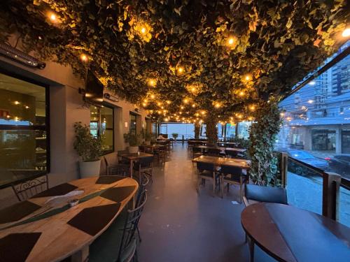 a restaurant with tables and chairs and lights on the ceiling at Hotel Mercu Privi Moema Ibirapuera com ar e piscina 1810 in Sao Paulo