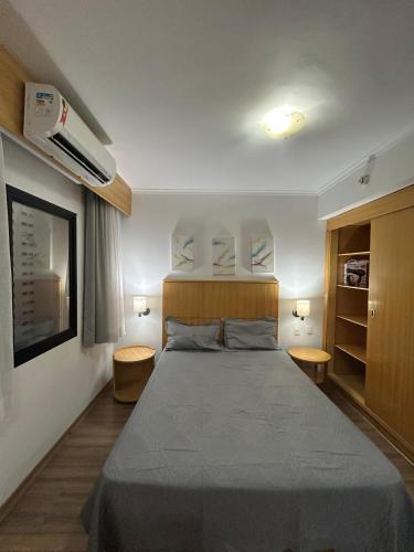 a bedroom with a large bed with two tables at Hotel Mercu Privi Moema Ibirapuera com ar e piscina 1810 in Sao Paulo