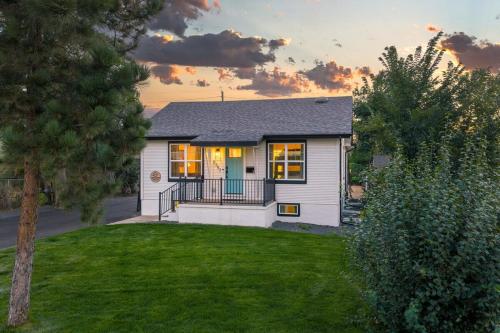 a small white house with a sunset in the background at Denver 5BR Hot Tub, Pool Table, Ping Pong! in Denver