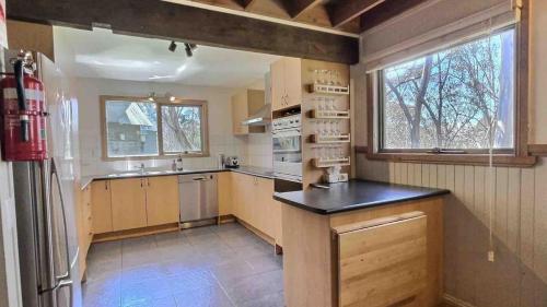 a large kitchen with a refrigerator and a window at Tanglewood in Dinner Plain