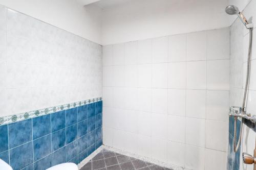 a bathroom with blue and white tiles and a toilet at Hotel Limaran 1 in Yogyakarta