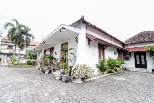 a white building with potted plants in front of it at Hotel Limaran 1 in Yogyakarta