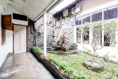 a building with a courtyard with a tree in it at Hotel Limaran 1 in Yogyakarta