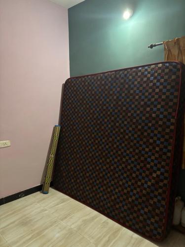 a large couch in a room with a wooden floor at Aswin's Homestay 1bhk in Podanūr